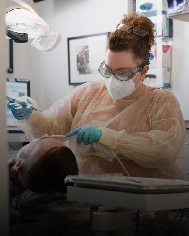 A dental hygienist completing a cleaning for a patient
