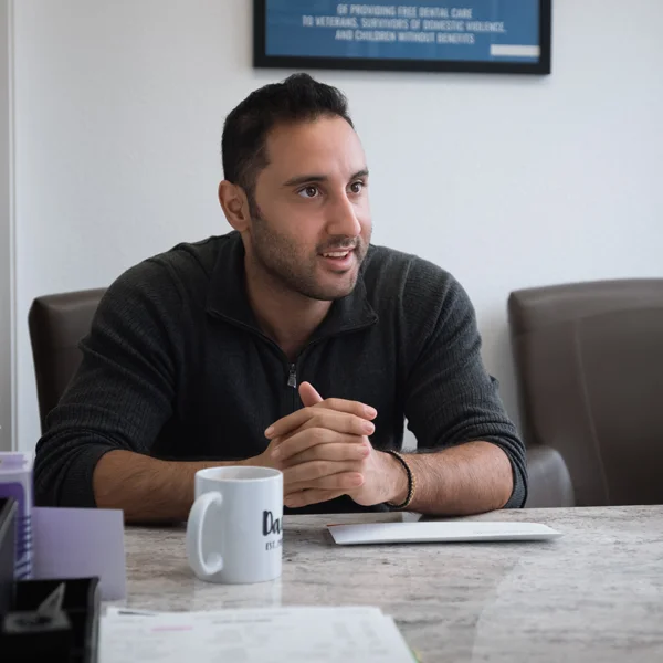 A patient sitting across the desk from a dental professional during a consultation